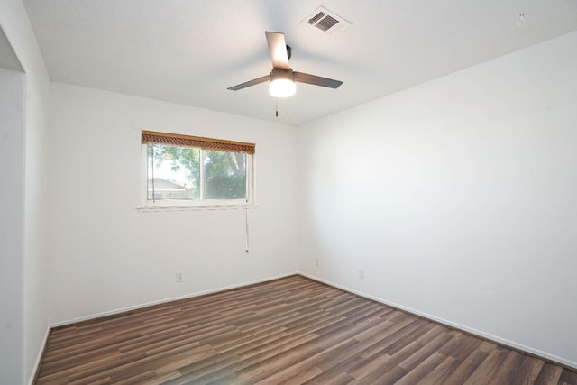 spare room featuring ceiling fan and dark wood-type flooring