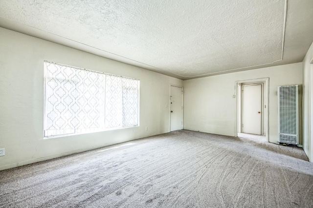 spare room with light colored carpet and a textured ceiling