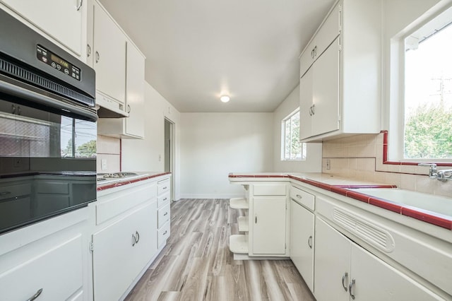 kitchen with white cabinets, tasteful backsplash, sink, and tile countertops