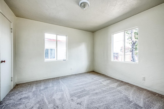 unfurnished room featuring carpet floors and a textured ceiling