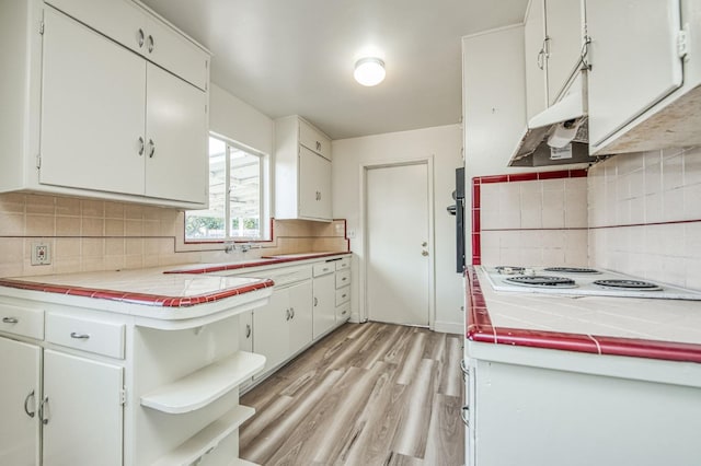 kitchen with white cabinets, decorative backsplash, tile counters, and white electric stovetop