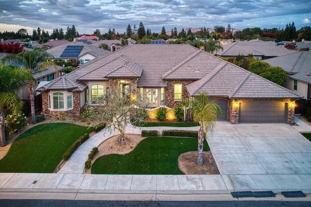 view of front of home with a garage and a yard