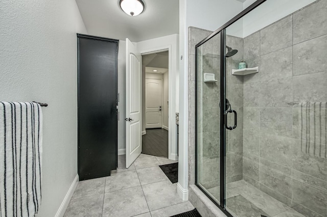 bathroom with tile patterned floors and a shower with door