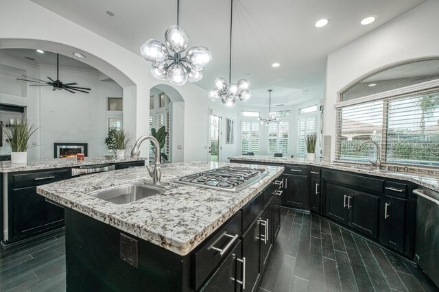 kitchen with light stone countertops, a kitchen island with sink, plenty of natural light, and stainless steel appliances