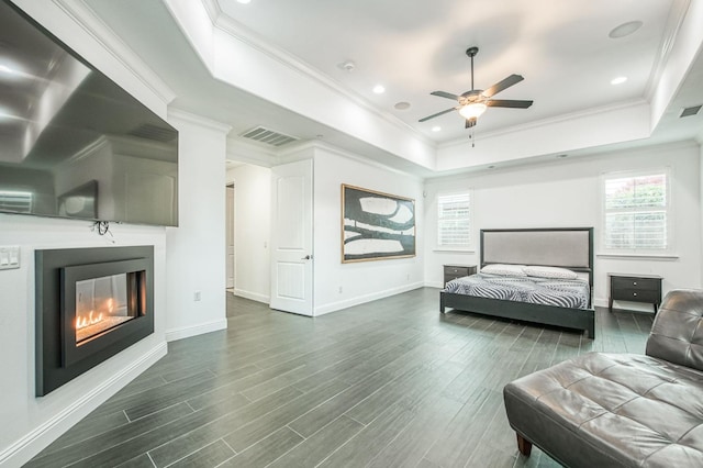 bedroom with a raised ceiling, ceiling fan, dark hardwood / wood-style flooring, and ornamental molding