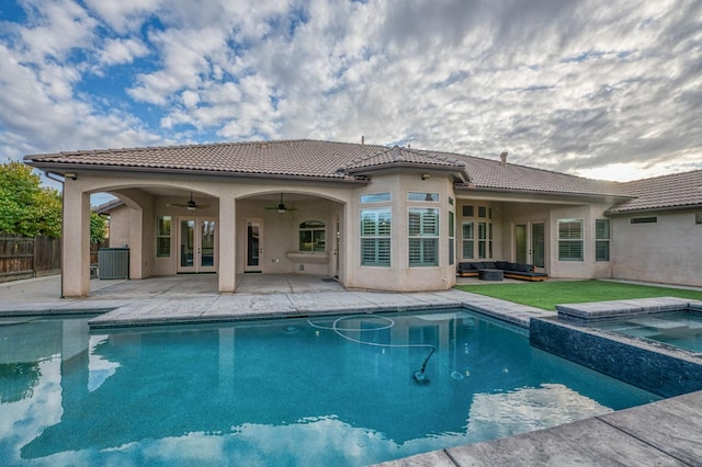 back of house featuring french doors, ceiling fan, a swimming pool with hot tub, central AC, and a patio