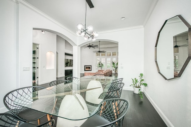 dining space with dark hardwood / wood-style flooring, ceiling fan with notable chandelier, and crown molding