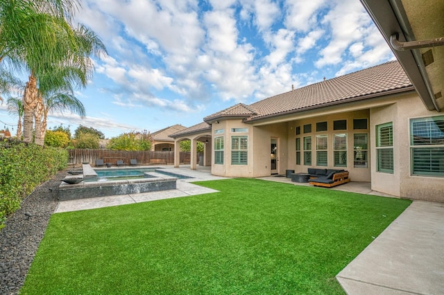 back of property featuring a lawn, an outdoor living space, a swimming pool with hot tub, and a patio area