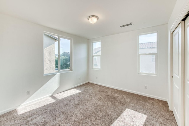 unfurnished room featuring light colored carpet