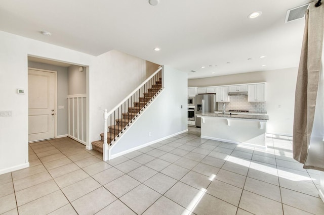 unfurnished living room with sink and light tile patterned floors