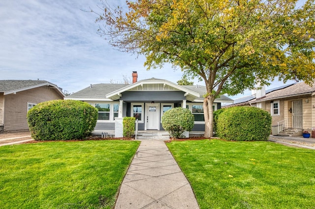 bungalow-style home featuring a front lawn