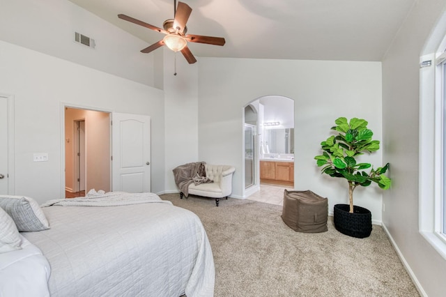 carpeted bedroom with ceiling fan, lofted ceiling, and ensuite bathroom