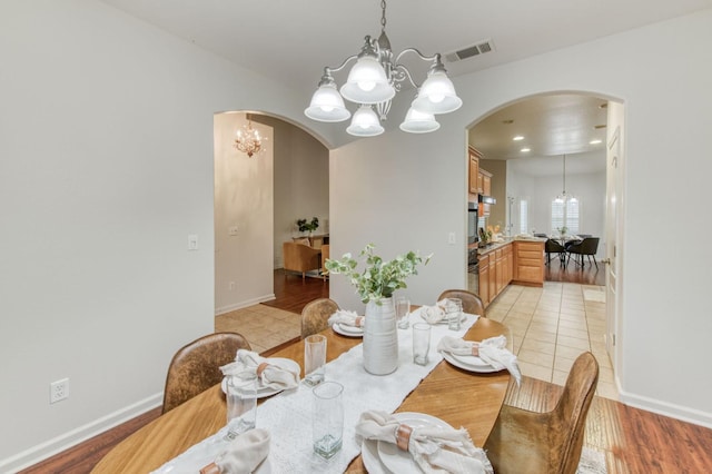 dining space featuring an inviting chandelier and light tile patterned floors