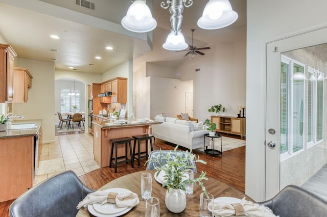 dining space with light tile patterned flooring, ceiling fan, and sink