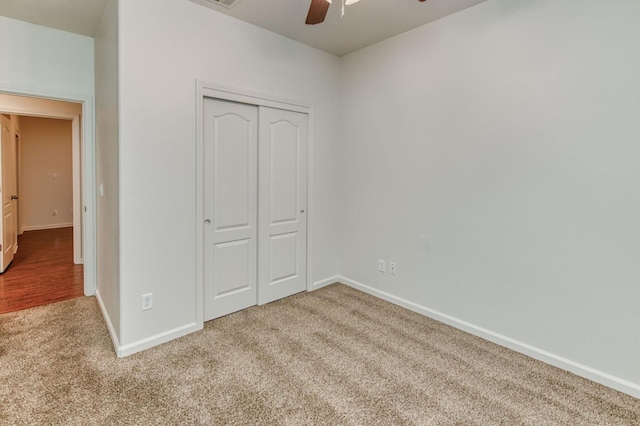 unfurnished bedroom with light colored carpet, a closet, and ceiling fan