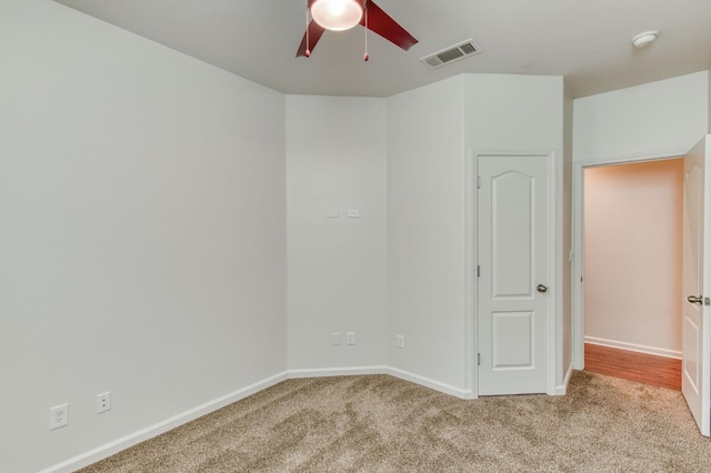 carpeted spare room featuring ceiling fan