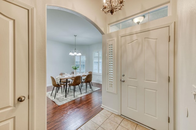 tiled entryway featuring an inviting chandelier