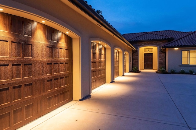 exterior space with stucco siding, stone siding, and a tiled roof