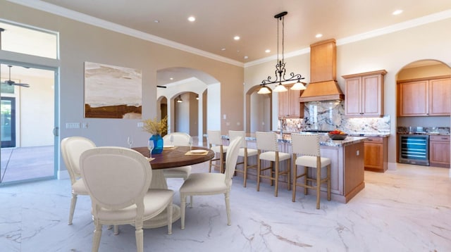 dining area featuring beverage cooler, recessed lighting, arched walkways, crown molding, and marble finish floor