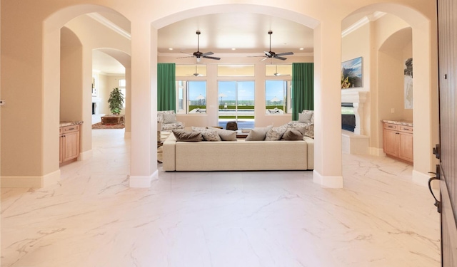 living room featuring baseboards, a fireplace, marble finish floor, and ornamental molding