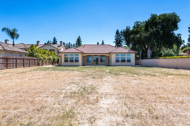 rear view of property featuring a lawn