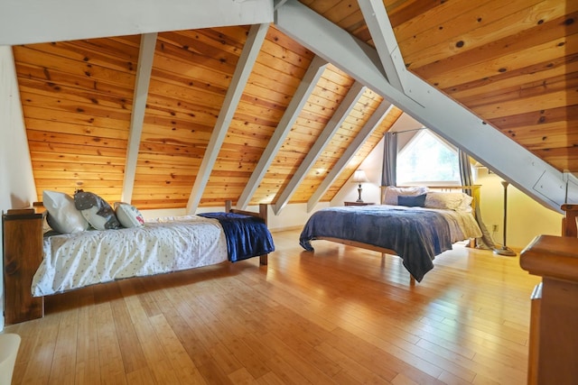 bedroom featuring light wood-type flooring, vaulted ceiling with beams, and wooden ceiling