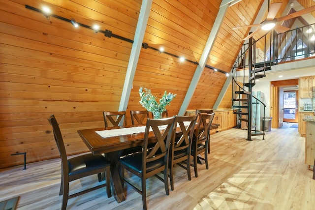 dining area with wooden walls, beam ceiling, light wood-type flooring, and wood ceiling