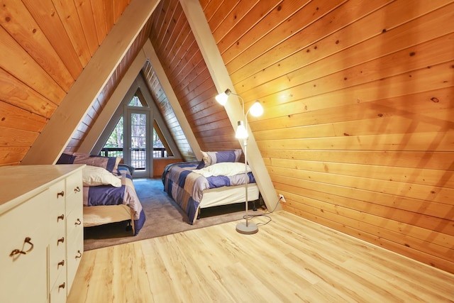 bedroom featuring lofted ceiling, light wood-type flooring, wooden ceiling, and wood walls