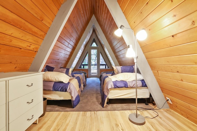 bedroom featuring wood walls, light wood-type flooring, and vaulted ceiling