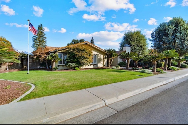 view of front of property featuring a front yard, fence, and stucco siding