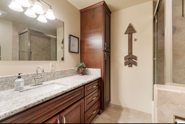 bathroom with a stall shower, tile patterned flooring, vanity, and an inviting chandelier