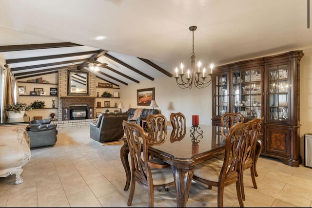 dining space with ceiling fan with notable chandelier, light tile patterned floors, lofted ceiling with beams, and a fireplace