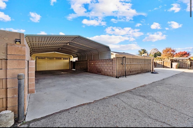 view of side of home with a garage, fence, and a carport