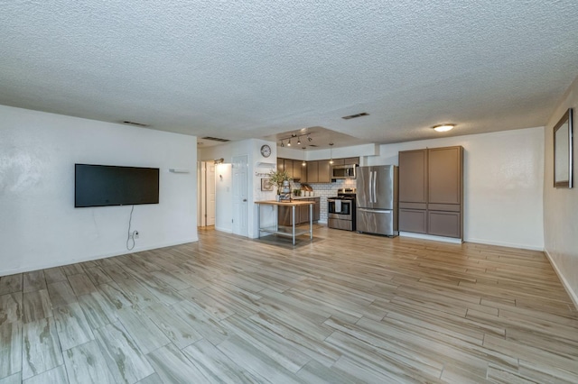 unfurnished living room featuring light hardwood / wood-style floors and a textured ceiling