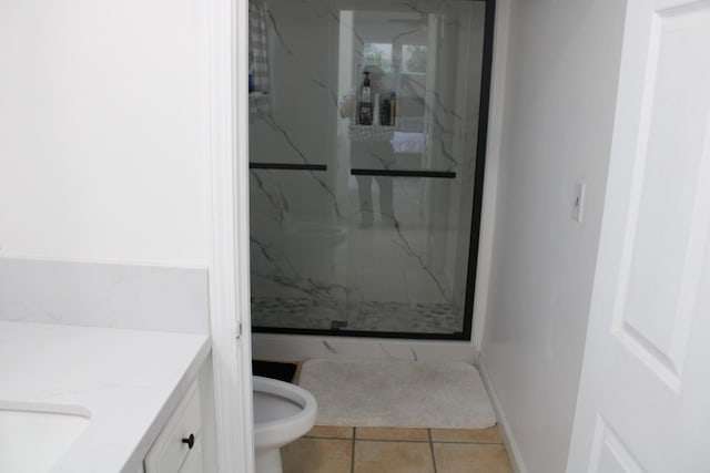 bathroom with tile patterned floors, vanity, toilet, and tiled shower