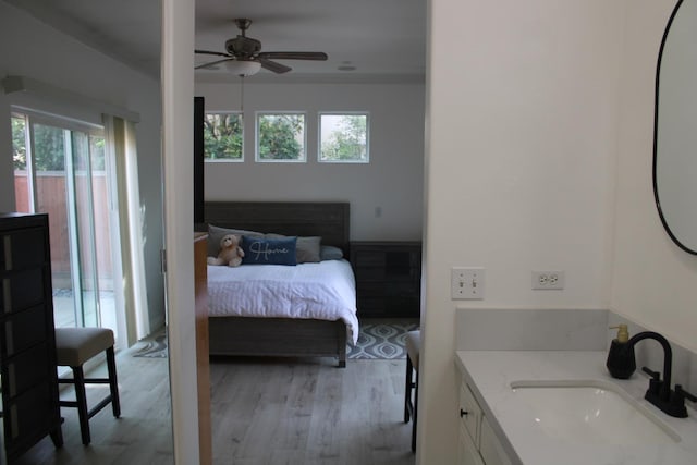 bedroom featuring ceiling fan, light hardwood / wood-style floors, crown molding, and sink