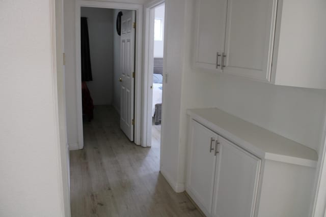 hallway with light hardwood / wood-style floors