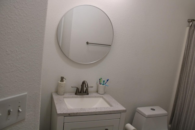 bathroom featuring vanity and toilet