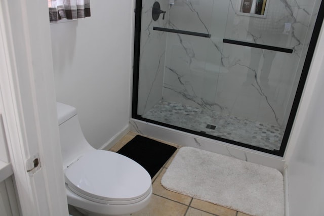 bathroom with tile patterned floors, toilet, and walk in shower