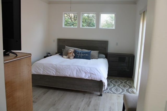 bedroom featuring light hardwood / wood-style floors and ornamental molding