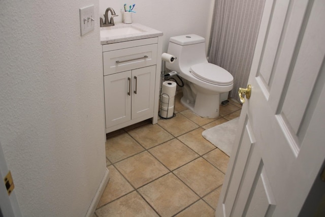 bathroom with tile patterned flooring, vanity, and toilet