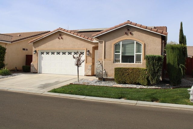 mediterranean / spanish-style home featuring solar panels and a garage