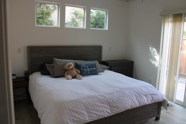 bedroom with access to exterior and wood-type flooring