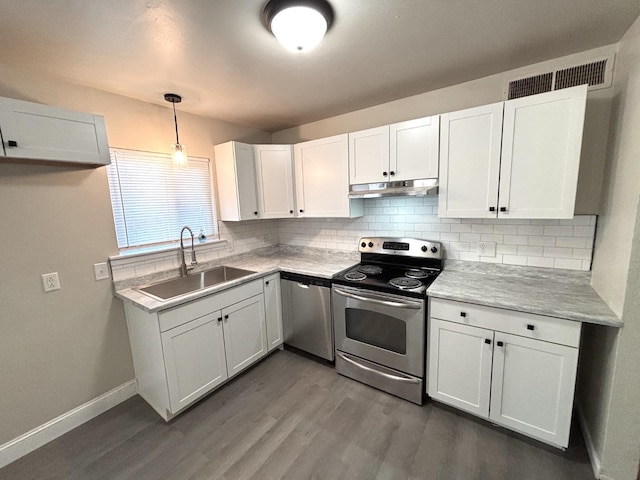 kitchen featuring dark hardwood / wood-style flooring, stainless steel appliances, sink, white cabinetry, and hanging light fixtures