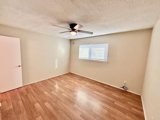 spare room with ceiling fan, light wood-type flooring, and a textured ceiling