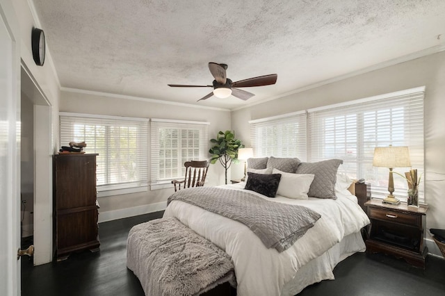 bedroom with ceiling fan, dark hardwood / wood-style floors, a textured ceiling, and multiple windows