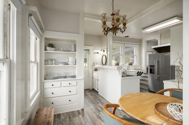 dining room with crown molding, a chandelier, and hardwood / wood-style flooring