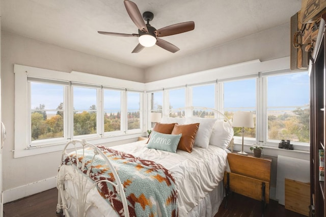 bedroom with multiple windows, ceiling fan, and dark hardwood / wood-style floors