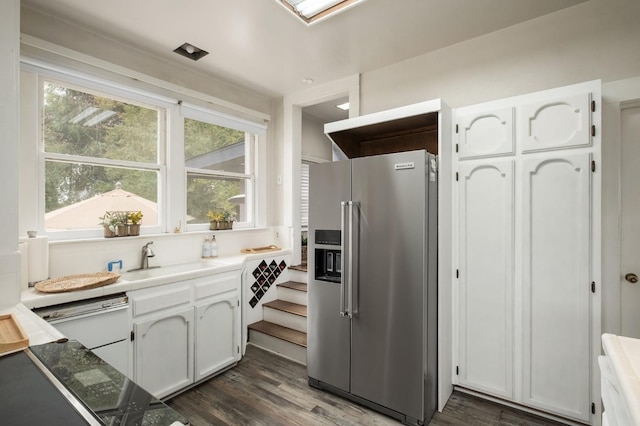 kitchen with white cabinetry, plenty of natural light, dark wood-type flooring, and stainless steel refrigerator with ice dispenser