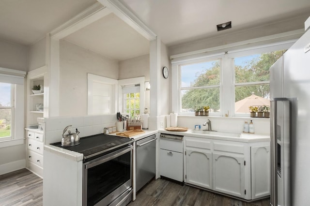 kitchen with kitchen peninsula, white cabinetry, dark wood-type flooring, and stainless steel appliances